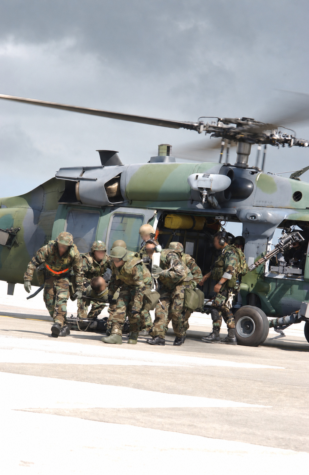 Aeromedical personnel unloading a simulated patient from an HH-60G Pave Hawk helicopter